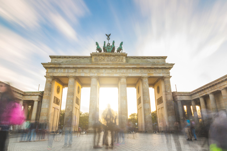 Berlin Brandenburg gate at sunset, long exposure. Blurred silhouette of people walking in Paris Square with the famous building on background. German name is Brandenburger Torの写真素材