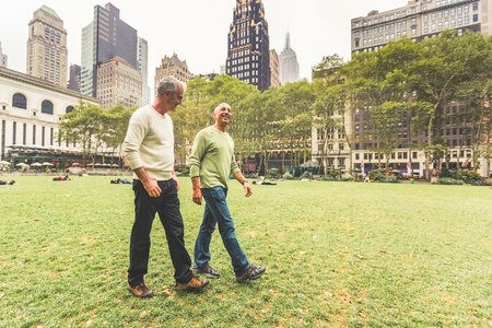 Gay couple walking at park in New York. Two senior men having a walk together in New York city. Homosexual senior couple conceptの写真素材