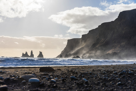 Black beach in Vik, Iceland. Big waves crashing and splashing on rocks at seaside. Nature and travel concepts in this remote country.の写真素材