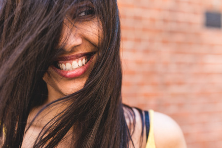Beautiful woman smile and portrait. Close up of an asian girl with long dark hair smiling and looking away from camera.の写真素材