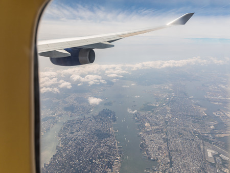 New York aerial view through airplane window. Beautiful panoramic view of Manhattan and Jersey city with plane engine and wing in foregroundの写真素材