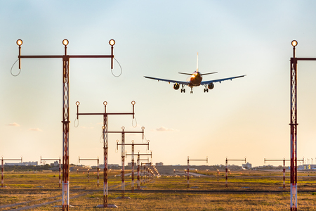 Airplane landing at sunset, rear view with approach lighting system.のeditorial素材