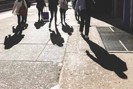 Shadows of people walking in New York on 5th avenue. Unrecognisable persons commuting, focus on...