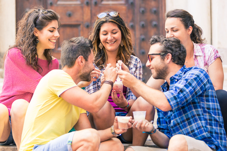 Group of friends eating slush ice cream in Italy. Tourists refreshing on a hot sunny day in Pisa. Best moments between friends, lifestyle and friendship conceptsの写真素材