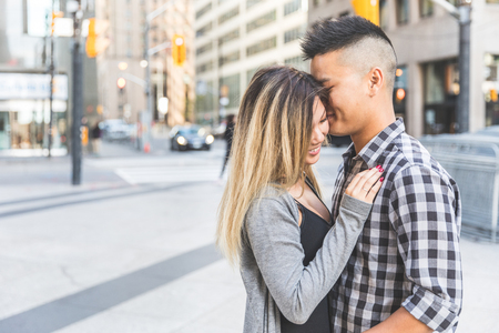 Asian couple in love togheter in the city. Chinese man and woman hanging out and embracing in Toronto. Love and relationship conceptsの写真素材