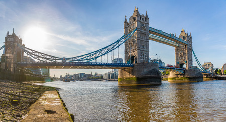 London Tower Bridge panoramic view from Thames river level. Backlight hdr shot of Tower Bridge and the river with cityscape on background. Travel and architectureの写真素材