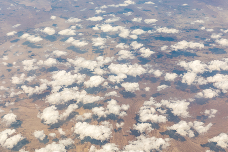 Aerial view of clouds over the desert. View from the airplane of clouds and their shadows. Location is a desert in the middle east. Travel and nature, also background ready image.の写真素材