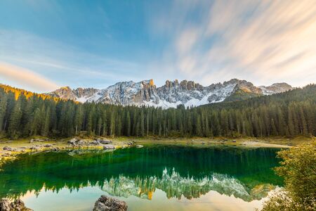 Lake Carezza or Karersee at sunset, wide angle view of scenic landscape in Italy. Dolomites mountains on background, Italian Alps. Nature and travel concepts, long exposure photoの写真素材