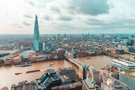 London aerial view with modern buildings and skyscraper, Thames river and clouds in the sky - Architecture and travel photo, teal and orange vintage filter applied - Beautiful London panoramic viewの写真素材