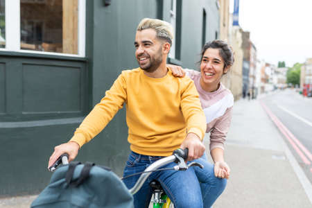 Happy couple taking a selfie with face mask on - Young man and woman taking a self portrait together and greeting the camera with hand gestures - lifestyle and happiness during coronavirurs pandemicの写真素材