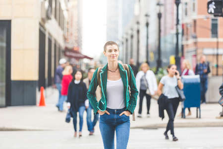 Confident young woman crossing the street in the city - Beautiful and successful woman wearing short hair and smart casual clothes - Lifestyle and travel in Chicagoの写真素材