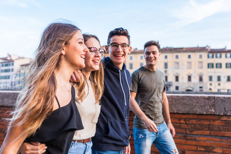Happy teenager friends walking together  in the city - Smiling and laughing young people happy to be together again and embracing - Friendship and lifestyle conceptsの写真素材