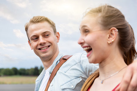 Happy couple having fun while on a walk together - Caucasian man and woman, best friends, sharing time and laughing in Berlin at Tempelhof airport park - Friendship and happiness lifestyle conceptsの写真素材