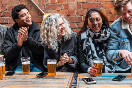 People enjoying a beer together at pub brewery - Happy laughing man and women talking and having fun in front of a pint - Lifestyle and drink concepts in Londonの写真素材