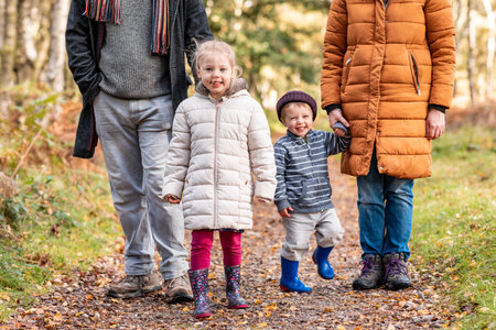 Happy family walking in the wood - Mother and father with daughter and son  on a path through the forest - Family and lifestyle conceptsの写真素材