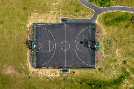 Aerial top down view of basketball court playground outdoor with green grass around it - Summer, playing games and outdoor activities concepts - background readyの写真素材
