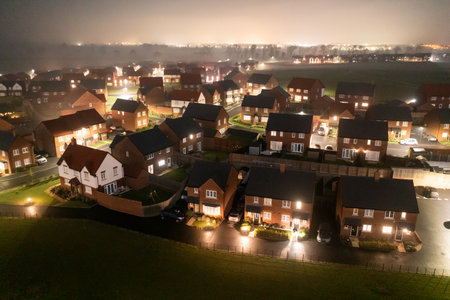 Aerial view of houses in England at night  - Drone view of a new estate with typical British houses and fog mist - Real estate and buildings concepts in UKの写真素材