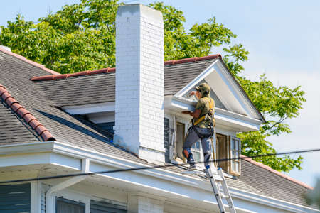 New Orleans, Louisiana/USA - 6/17/2020: Painter working on third story of house next to ladderのeditorial素材