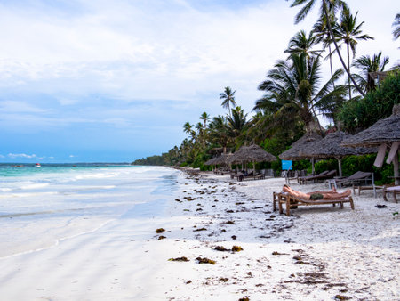 Unidentifiable People Laying on the Beach on the Northeast Coast of Zanzibar, Tanzaniaの写真素材