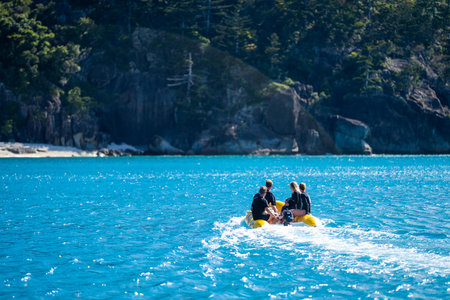 tourist boats and tour boats in the whitsundays queensland, australia. travellers on the great barrier reef, over coral and fish. tourism yachts of young people partying on the waterのeditorial素材
