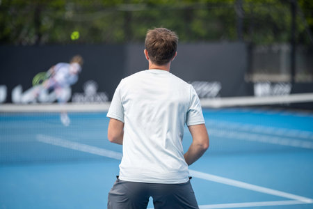 Tennis player serving in a tennis match, with leg drive in a game of sportの写真素材