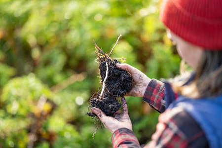 Female farmer hold soil in hands monitoring soil health on a farm in australia