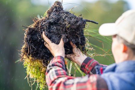 female farmer holding soil looking at soil carbon in the americaの写真素材