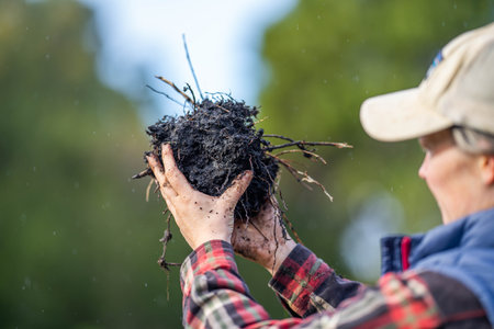 female farmer holding soil looking at soil carbon in the america