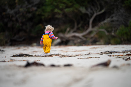 baby on the beach in yellow overalls in springの写真素材