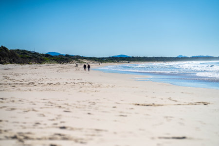 walking on the beach at dusk on an australian sandy beach in summerの写真素材