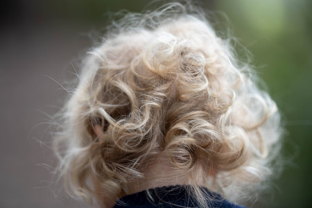 Curly blonde hair of a child. Selective focus and shallow depth of field.の写真素材