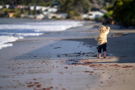 little girl child running on the beach at the seaside in summerの写真素材
