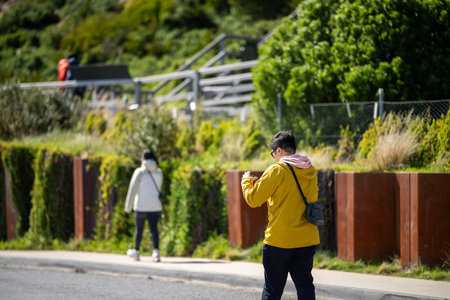 asian tourist in yellow coat on holidayの写真素材