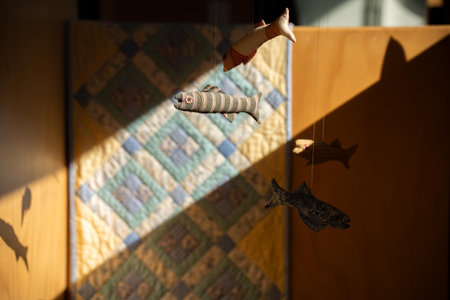 hand made fish baby mobile hanging in a bedroom in a houseの写真素材