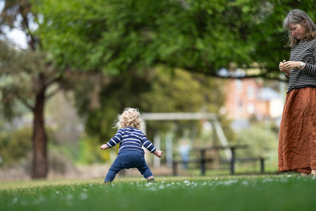 Mother and daughter playing together in a park on a sunny day.の写真素材