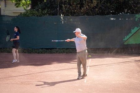 friends playing social tennis club on a clay tennis courtの写真素材