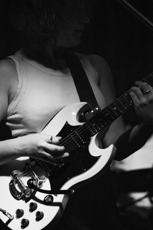 female musician playing guitar band at a rock show to an audience watching. sound check with a switcherの写真素材
