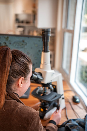 farmer collecting soil samples in a test tube in a field. Agronomist checking soil carbon and plant health on a farm with a microscope soil testの写真素材