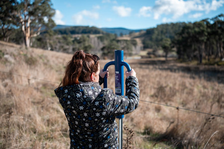 female farmer driving steel posts with a post driver on a farm putting up a steel post fence with high tensile wire in australia women in agriculture in springの写真素材