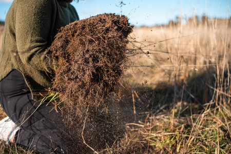 Farmer in the field with a huge anthill. Selective focus.