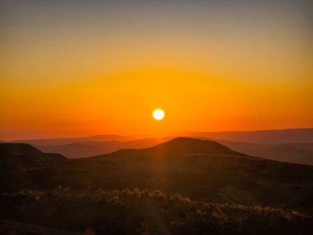 Sunset in the mountains seen from inside a mesh fenceの写真素材