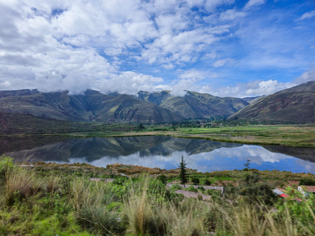 High Andean landscape with clouds, grasslands and lagoon.の写真素材
