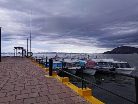 Pier with boats on the lake with cloudy sky.の写真素材