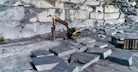 Mining machinery extracting ornamental rock in a quarry working on sidewalksの写真素材