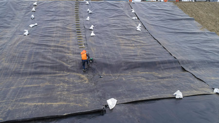 Geomembrane deployment and installation process with machinery in the construction of water poolsの写真素材