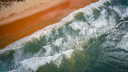 Sea with turquoise water and beach with orange sand