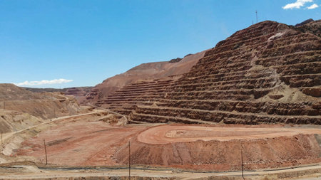 View of open-pit mine benches next to fill of surplus excavation material