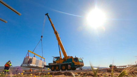 Telescopic crane being lifted for assembly of metal structures and construction materials