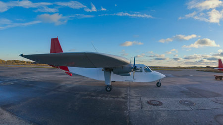 View of a propeller-powered plane preparing for takeoff from an airfield near meadows