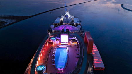 View of a cruise ship leaving port, sailing at sea, carrying people on vacation
